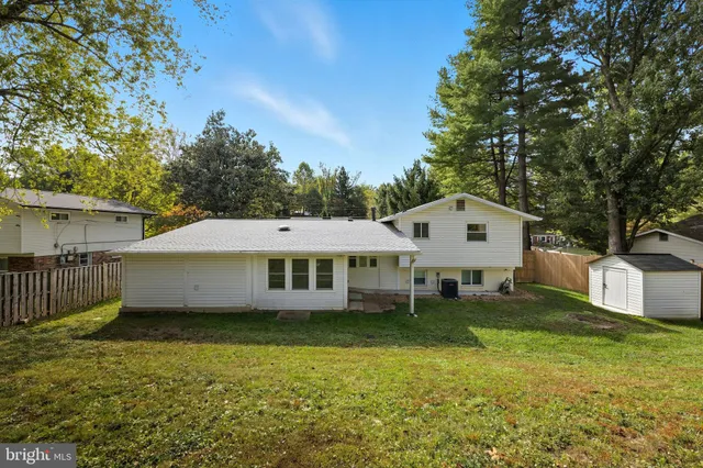 a view of a house with a big yard and large trees