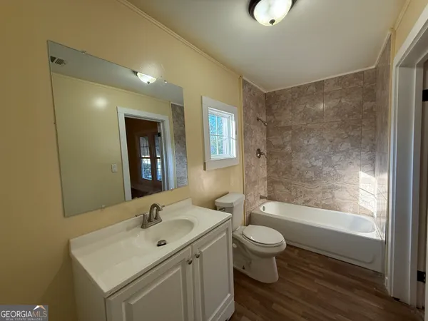 a bathroom with a granite countertop toilet a sink and a bathtub