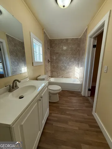 a bathroom with a granite countertop toilet a sink and a bathtub