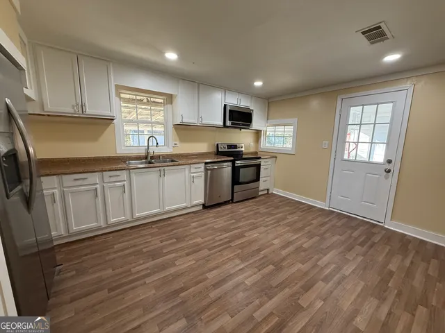 a kitchen with granite countertop a sink and wooden cabinets
