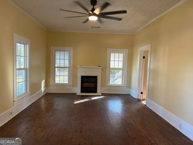 a view of an empty room with window and wooden floor