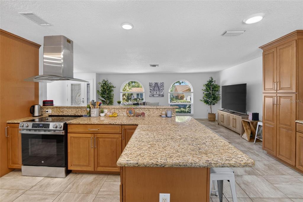 1668 Allens Ridge Drive North Palm Harbor, FL 34683 - Photo 11 of 48 a kitchen with kitchen island granite countertop a sink stove and refrigerator