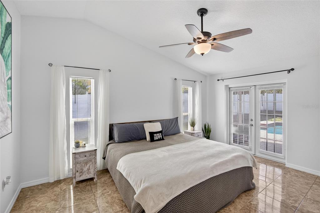 1668 Allens Ridge Drive North Palm Harbor, FL 34683 - Photo 19 of 48 a bedroom with a large bed and a chandelier