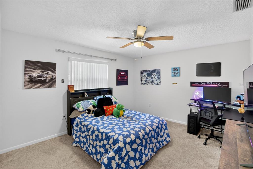 1668 Allens Ridge Drive North Palm Harbor, FL 34683 - Photo 28 of 48 a bedroom with a bed a window and a flat screen tv