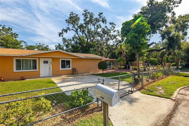 a view of a house with backyard and sitting area