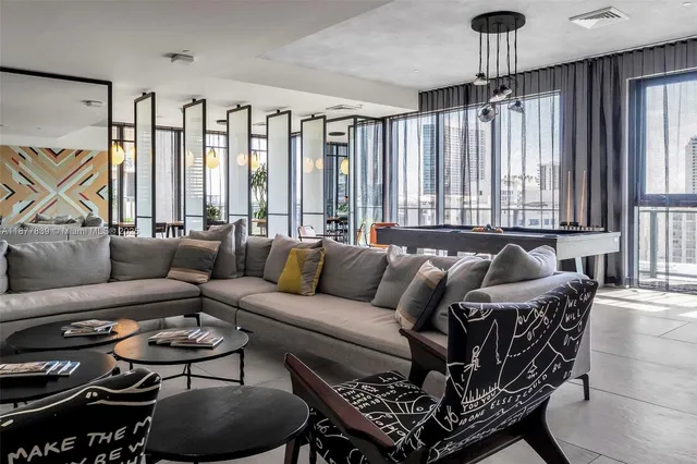 a living room with furniture a bookshelf and a window