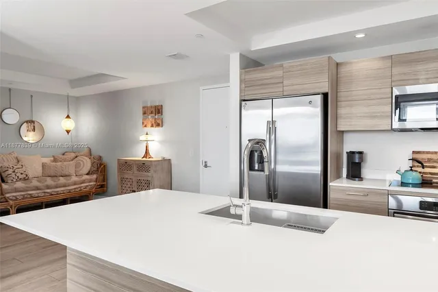 a kitchen with stainless steel appliances kitchen island granite countertop a refrigerator a stove and a sink