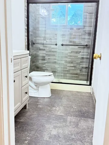 a bathroom with a toilet and a shower