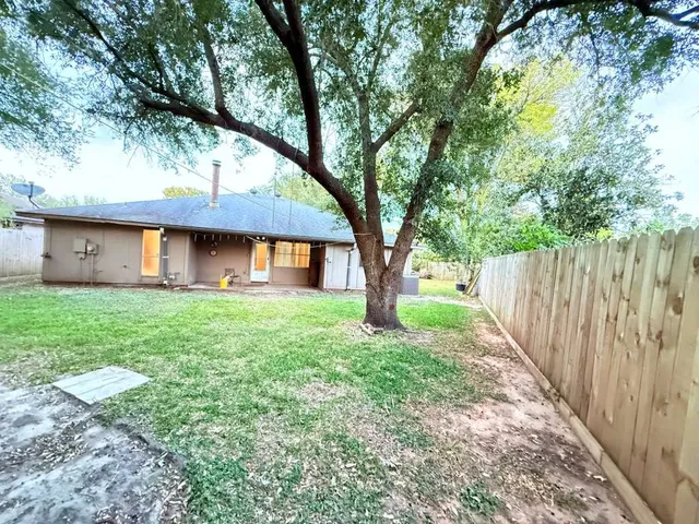 a view of a house with backyard and a tree