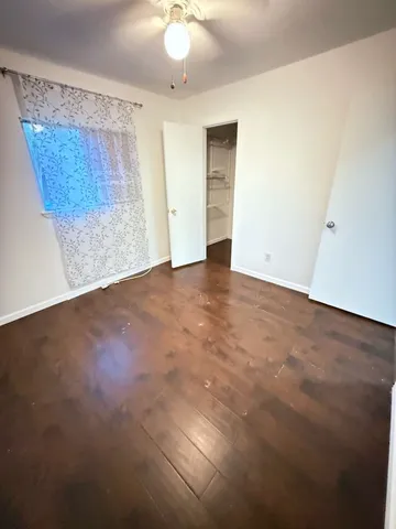 an empty room with a ceiling fan and a window