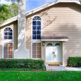 a view of a house with brick walls and a yard with plants