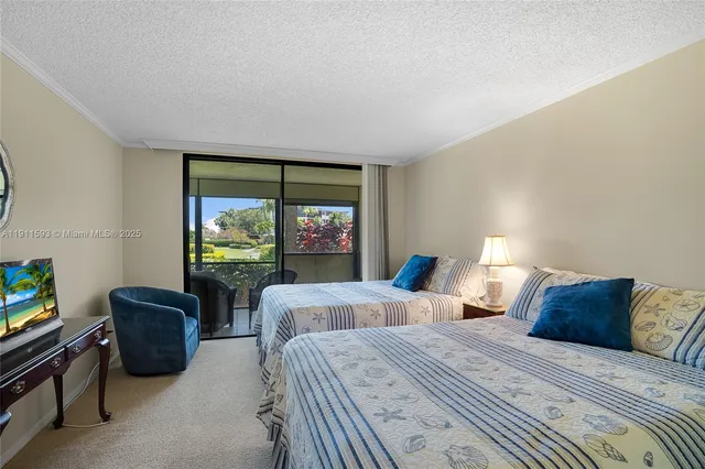 a bedroom with two beds and a flat screen tv