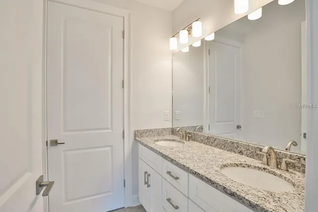 a bathroom with a granite countertop sink and a mirror
