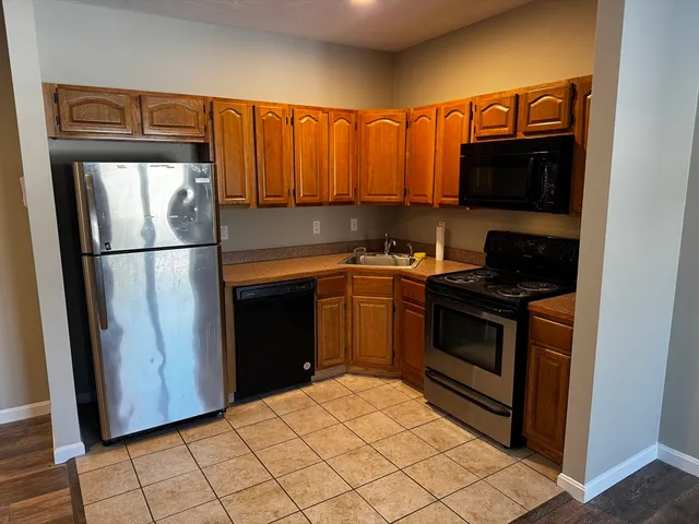 a kitchen with a refrigerator sink and cabinets