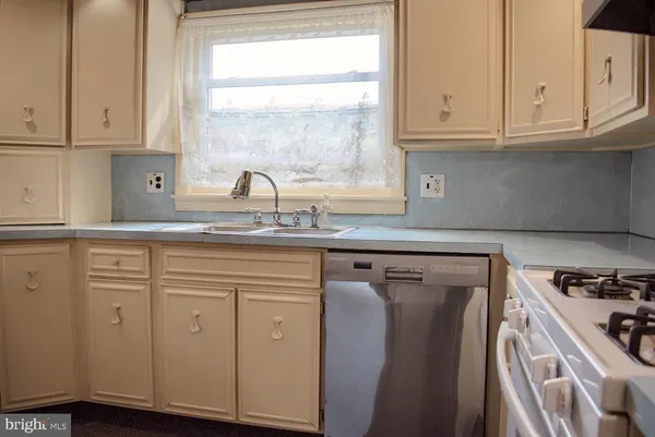 a kitchen with granite countertop cabinets stainless steel appliances a sink and window