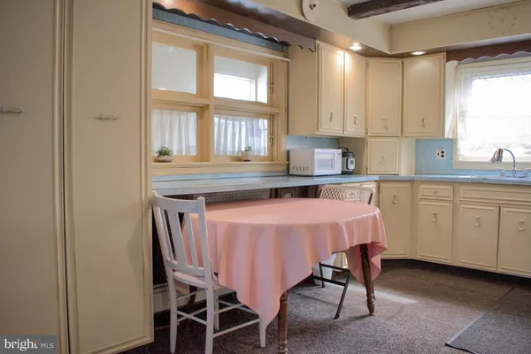 a kitchen with a table chairs refrigerator a sink and dishwasher with wooden floor