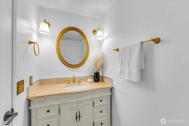 a bathroom with a granite countertop sink and a mirror