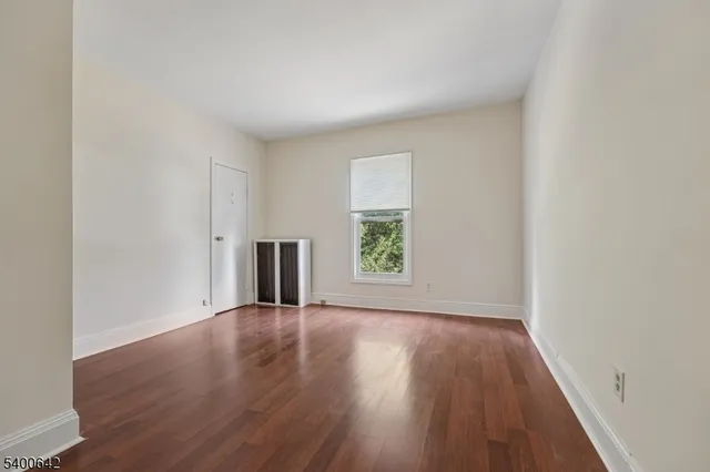 a view of a big room with wooden floor and windows