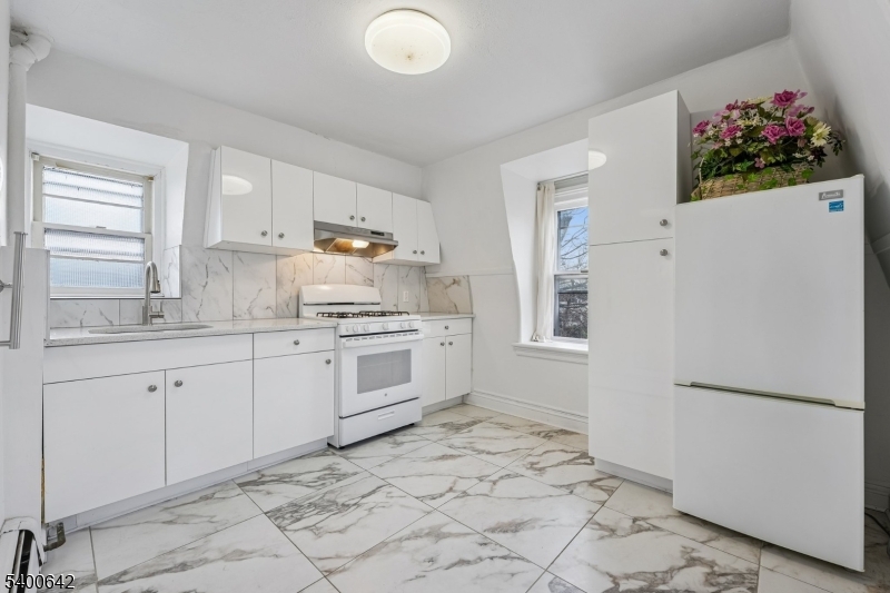 24 Franklin Place Summit, NJ 07901 - Photo 19 of 36 a kitchen with white cabinets and white appliances