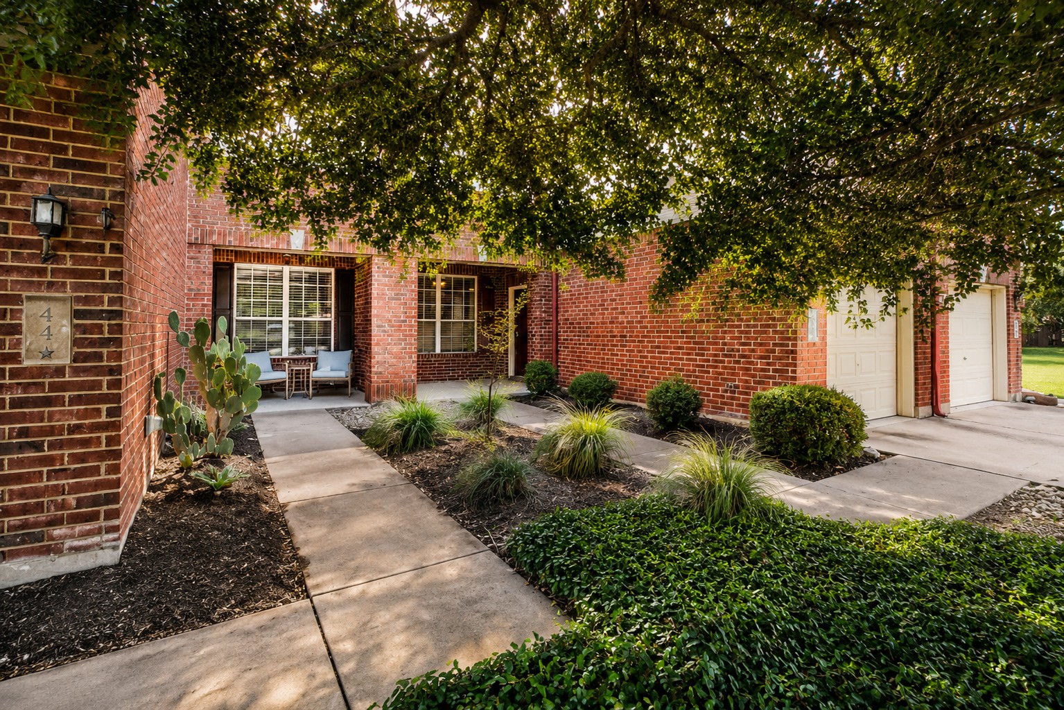 46 Verde Ranch Loop Leander, TX 78641 - Photo 1 of 19 Mature trees shade this inviting brick residence, featuring a welcoming covered porch and meticulously landscaped front yard.