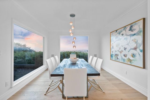 a kitchen with stainless steel appliances granite countertop a stove top oven a sink dishwasher a dining table and chairs with wooden floor