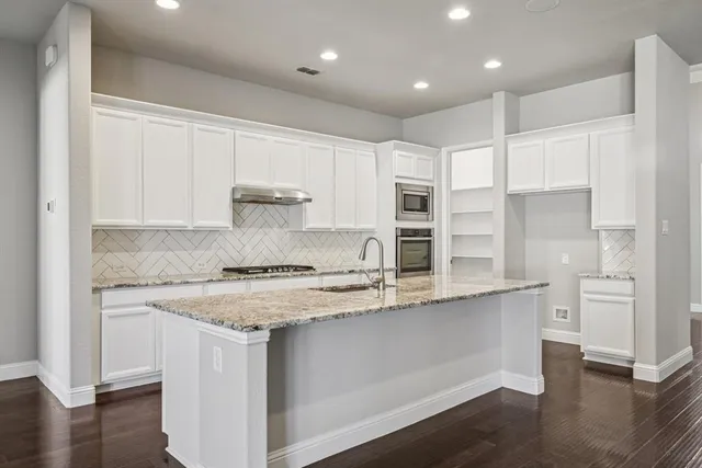 a kitchen with stainless steel appliances granite countertop a sink and cabinets