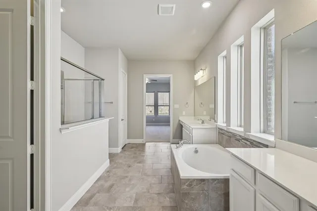 a bathroom with a tub sink and mirror