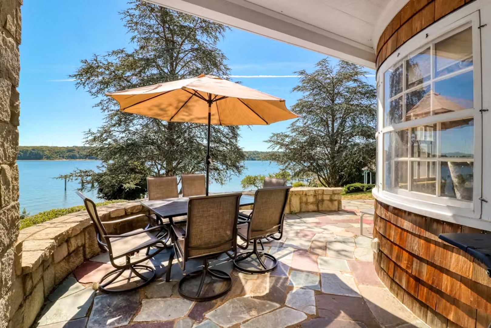 57 Hines Point Road Vineyard Haven, MA 02568 - Photo 14 of 29 a view of a patio with a table and chairs under an umbrella