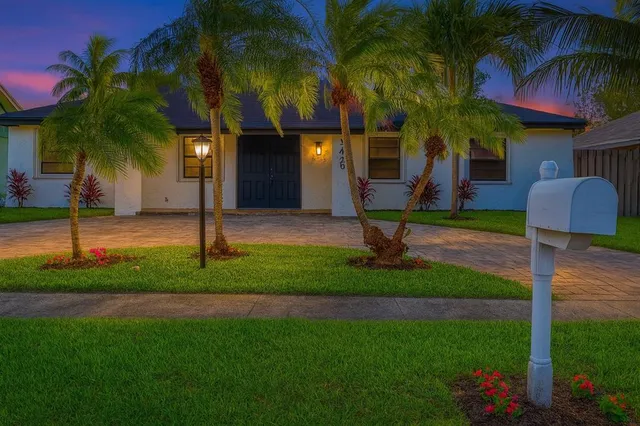 a front view of a house with garden and plants