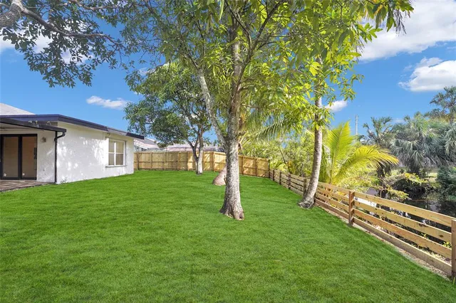 a view of a house with backyard and a tree