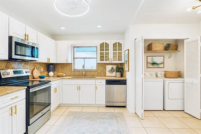 a kitchen with stainless steel appliances granite countertop a refrigerator and a stove top oven