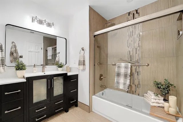 a bathroom with a tub sink and mirror