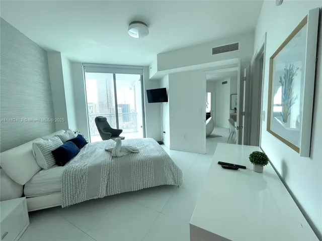 a bedroom with bed and glass windows