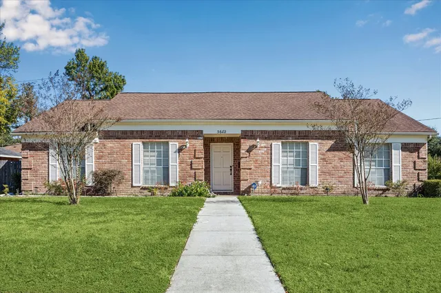 a front view of a house with a yard and fountain