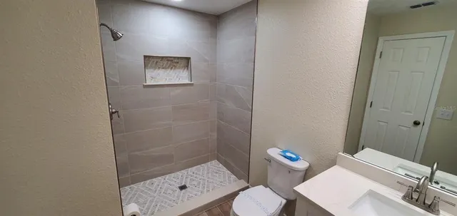 a view of a room with wooden floor a ceiling fan