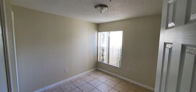 a view of an empty room with window and closet area