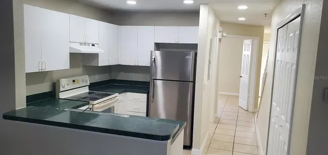 a kitchen with kitchen island a refrigerator and a sink