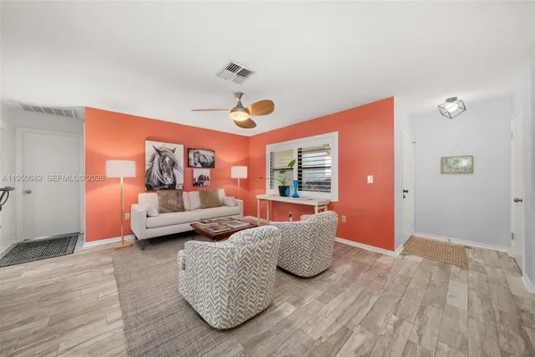 a living room with furniture and a wooden floor