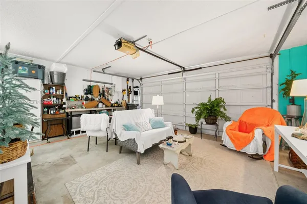 a living room with patio furniture and a potted plant