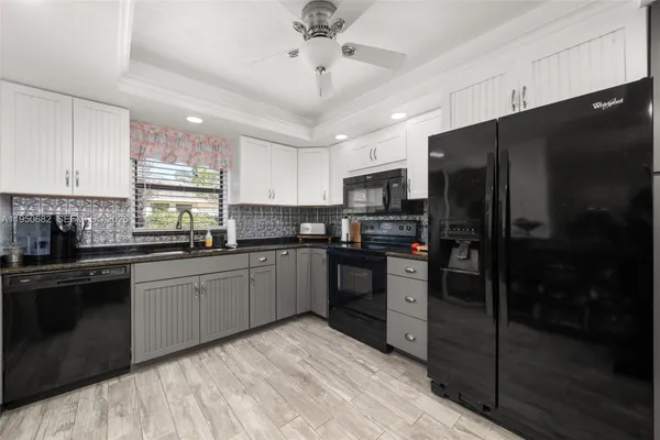 a kitchen with a refrigerator a sink a stove a microwave and cabinets