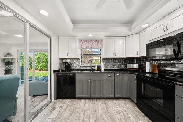 a kitchen with stainless steel appliances granite countertop wooden cabinets a stove a sink and a microwave