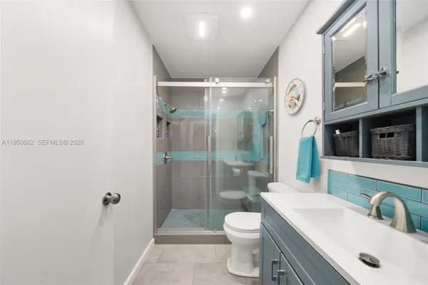 a bathroom with a sink a toilet and shower