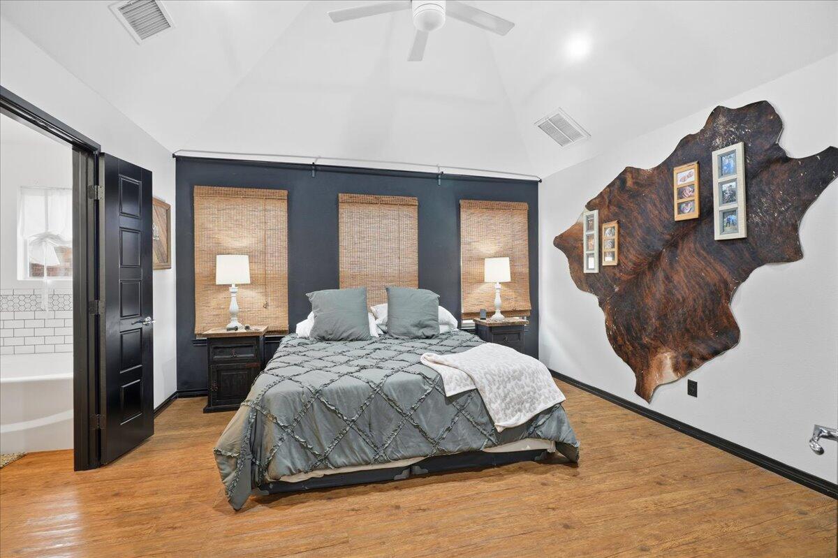 3013 111th Street Lubbock, TX 79423 - Photo 17 of 37 a bedroom with a large bed and wooden floor