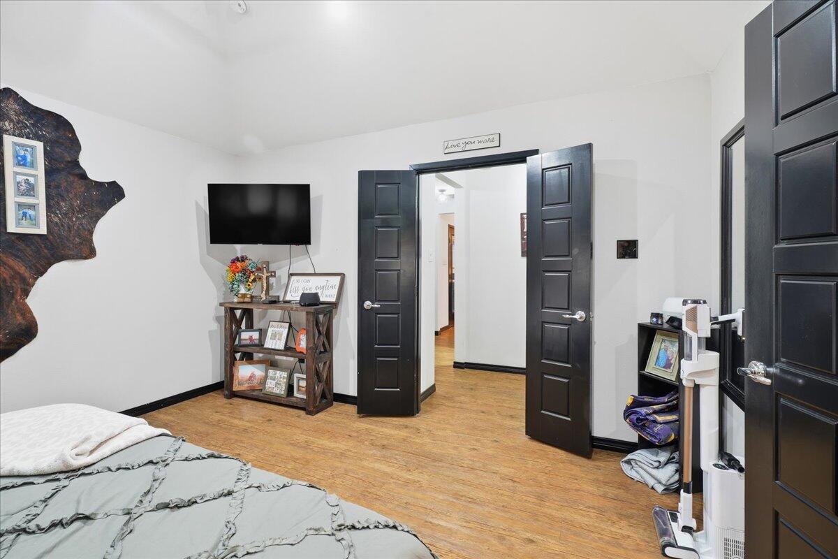 3013 111th Street Lubbock, TX 79423 - Photo 19 of 37 a bedroom with a bed and a flat screen tv