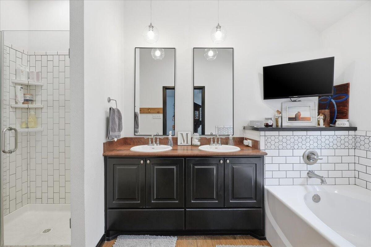 3013 111th Street Lubbock, TX 79423 - Photo 20 of 37 a bathroom with a granite countertop sink and a bathtub