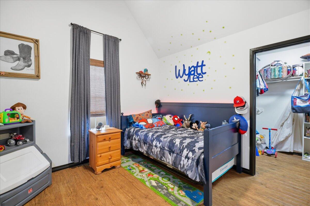 3013 111th Street Lubbock, TX 79423 - Photo 29 of 37 a bedroom with a bed and wooden floor