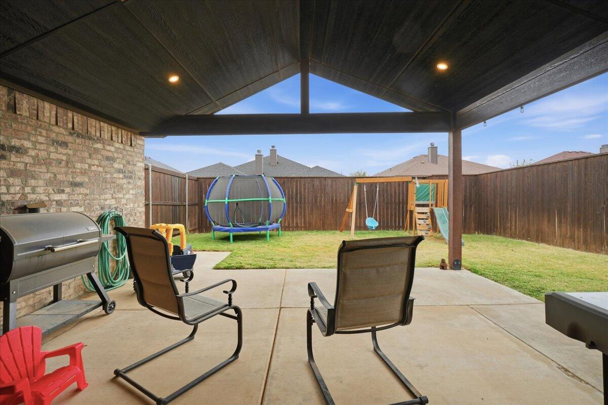 3013 111th Street Lubbock, TX 79423 - Photo 35 of 37 a view of a patio with table and chairs with wooden fence