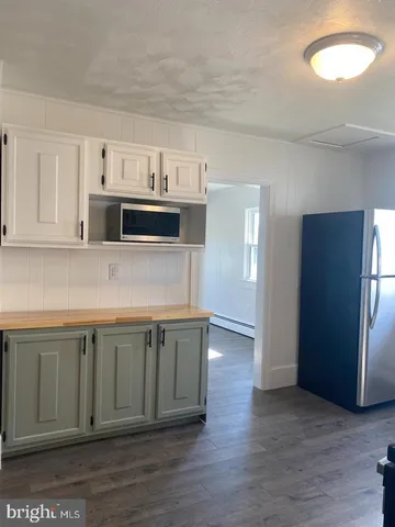 a view of kitchen with stainless steel appliances granite countertop cabinets and wooden floor