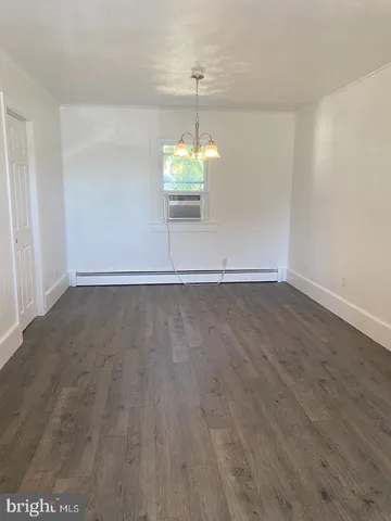 a view of a room with wooden floor and chandelier