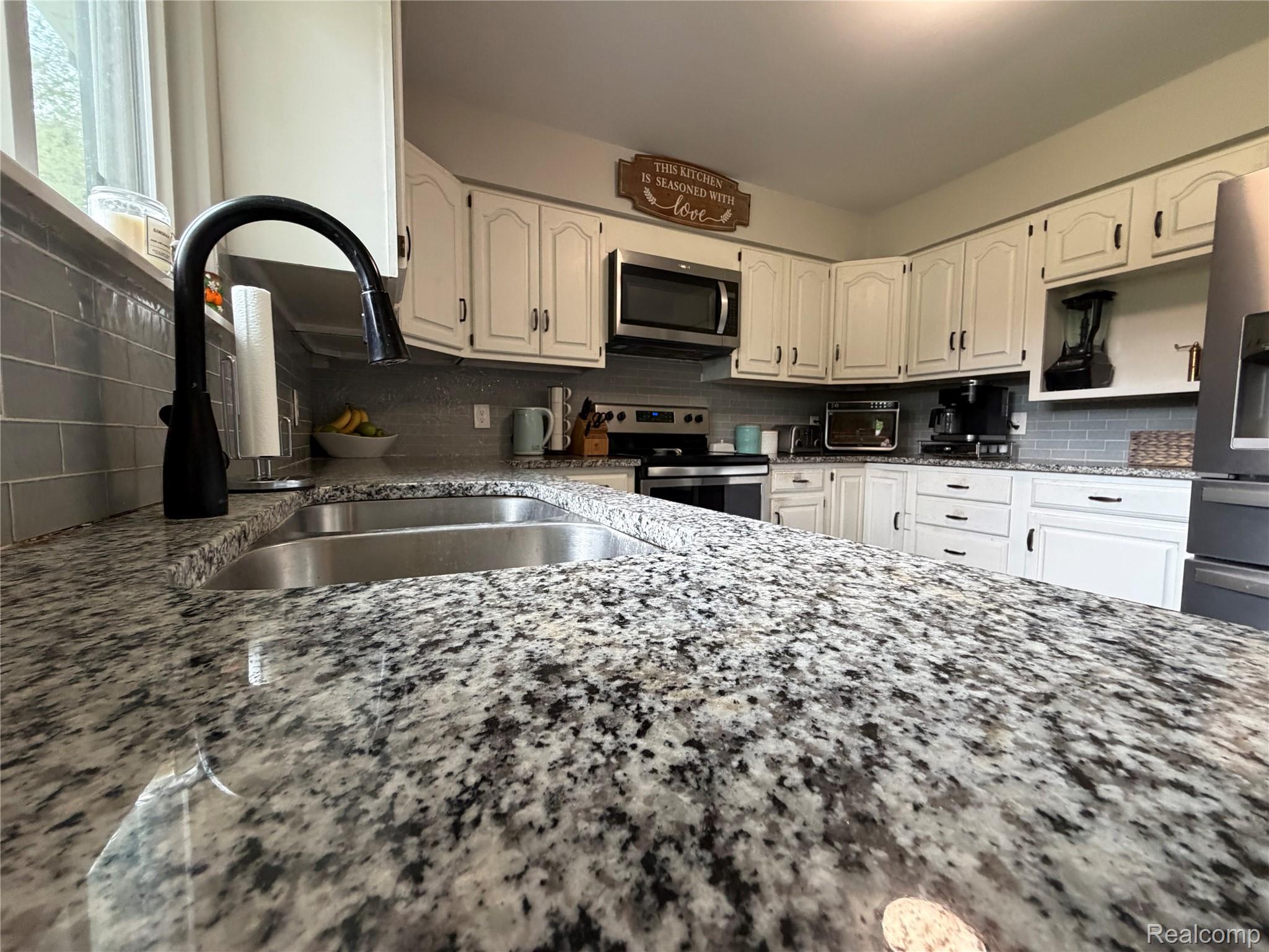 2712 North Branch Road North Branch, MI 48461 - Photo 15 of 37 Kitchen featuring tasteful backsplash, white cabinetry, stainless steel appliances, and light stone countertops